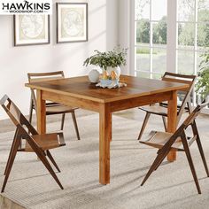 a wooden table with four chairs in front of it and a potted plant on top