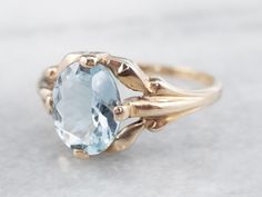 This stunning aquamarine has been set into this Retro era solitaire ring. The cool blue tones contrast beautifully with the warmth of the vintage mounting, while the tapered shoulders draw light into the sparkling gem. This is a lovely piece that is pretty enough to wear alone, yet versatile enough to stack with other rings!Metal: 10K Yellow GoldGem: Aquamarine 1.37 CaratsGem Measurements: 8.5 x 6.9 mm, OvalRing Size: 5.25Marks: "10K" Stamped on the inside band Classic Topaz Ring With Round Cut, Classic Round Cut Topaz Ring, Formal Light Blue Topaz Ring, Classic Blue Topaz Solitaire Ring, Classic Blue Topaz Ring With Accent Stones, Classic Topaz Ring With Center Stone, Classic Topaz Birthstone Ring, Classic Blue Topaz Ring With Center Stone, Classic Blue Topaz Ring For Formal Occasions