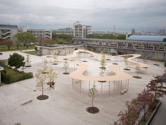 an aerial view of a park with trees and benches on the ground in front of buildings