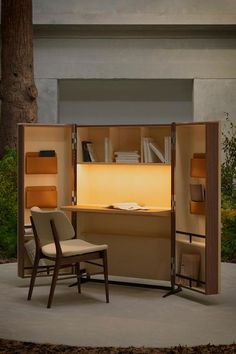 an office cubicle with two chairs and a desk in the center, lit up by a lamp