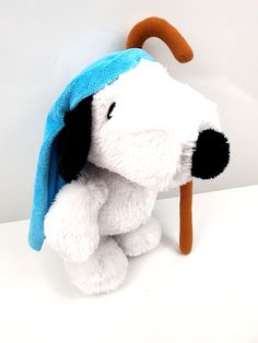 a stuffed dog with a blue hat on it's head sitting against a wall