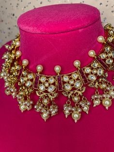 This beautiful traditional modern jadau choker comes with gorgeous matching earrings and is handcrafted with kundan work. The pearl hangings and spiked pears add a touch of elegance to this piece. Great for any event as it‰۪s in a color that can go with any outfit! Chandbali Kundan Necklace With Pearl Drop, Bollywood Kundan Bridal Necklace With Pearl Drop, Festive Kundan Pearl Necklace For Party, Kundan Chandbali Necklace With Pearl Drop, Traditional Kundan Bridal Necklace With Pearl Drop, Festival Kundan Temple Necklace With Pearl Drop, Party Kundan Choker With Tilla Details, Festive Kundan Temple Necklace With Pearl Drop, Festive Heavy Kundan Pearl Necklace