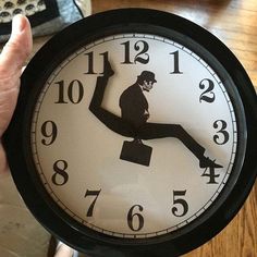 a person holding up a clock with the image of a monkey on it