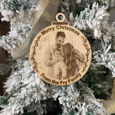 a christmas ornament hanging from the side of a tree with a photo on it