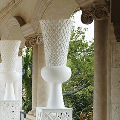 three white vases sitting on top of each other in front of a gazebo