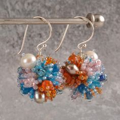 Bright Colors Orb Earrings - Coral Reef Nature Inspired Earrings. Handmade with a striking mix of orange, blue, and pink beads, these earrings draw inspiration from the vivid beauty of coral reefs.  Accented with lustrous pearls and faceted crystals, the playful, three-dimensional design creates a unique, statement jewerly with coral reef vibes.  The silver drop hooks add a refined touch, making these earrings a perfect choice for special occasions or as a thoughtful gift for Mom. Ideal for wedding guests, mother of the bride or mother of the groom, festive gatherings, or to elevate everyday style with a splash of color.  SIZE   Bright Colors Orb Earrings are 1.18'' (3 cm) long and the vibrant handmade ball is 0,7'' (1,8 cm).  HANDMADE   Lovingly Created in My Little Studio in the Heart of Orb Earrings, Wedding Guest Accessories, Coral Reefs, Pink Beads, Silver Drop Earrings, Faceted Crystal, Coral Reef, Mother Of The Groom, Blue And Pink