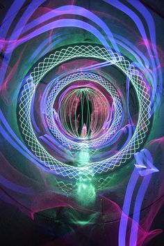 an abstract photo with purple and green lights in the center, as if it were light painting