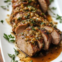 some meat is on a white plate with sauce and garnishes around it