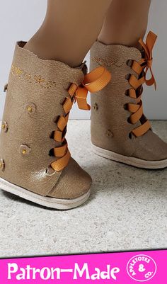 a pair of brown boots with orange bows on them