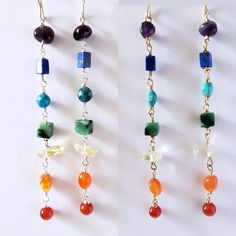 Vibrant gemstones wired wrapped in your choice of 14k goldfilled or sterling silver wire. Gems are rich in color and coordinate with the seven energetic Chakra colors. From top to bottom, it includes amethyst, lapis, apatite, (turquoise for gold version),  jade, citrine, carnelian and red agate. Earrings hang 4" in length.  It's said that wearing or holding certain stones helps keep us more in balanced with our emotions and attract good energy. Each stone coraltes with a part of the body from the crown (amethyst) which is said to help us see the bigger picture, to the root  (red agate) which lends to keeping us grounded.   Even if you dont subcribe to the notion that a stone can have any influence over your energy centers. Wear them because these fun, vibrant, gorgeous hued gems will certa 14k Gold-filled Yellow Gold Earrings With Natural Stones, Yellow Gold Wire Wrapped Jewelry For Healing, Gold Natural Gemstones In Sterling Silver, Fusion Wire Wrapped Dangle Jewelry, Spiritual 14k Gold Filled Dangle Jewelry, Wire Wrapped Healing Drop Earrings, Healing Wire Wrapped Drop Earrings, Rainbow Sterling Silver Jewelry With Ear Wire, Wire Wrapped Fusion Earrings For Gift