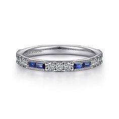 an 18k white gold diamond and blue sapphire wedding band with channel set diamonds on the sides