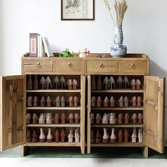 there is a cabinet with many pairs of shoes on the top and bottom shelves in front of it