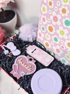 an open box with various items in it on a table next to a flower pot