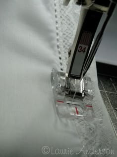 the sewing machine is on top of the white material that's stitched together