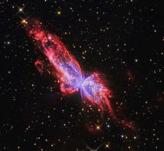 a very colorful butterfly shaped object in the middle of some dark space with stars around it