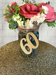 a vase filled with flowers sitting on top of a table next to a brick wall