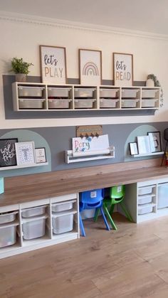 there is a desk with bins and shelves on the wall in this playroom