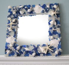 a blue and white mirror sitting on top of a mantle