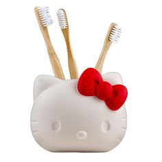 two toothbrushes in a hello kitty container with red bows on the front and bottom