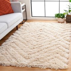 a living room with a white couch and rug