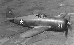 an old black and white photo of a fighter plane flying in the sky over land