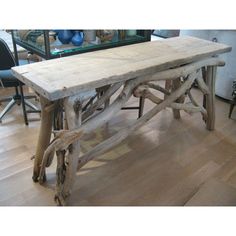 a wooden table sitting on top of a hard wood floor next to a glass case