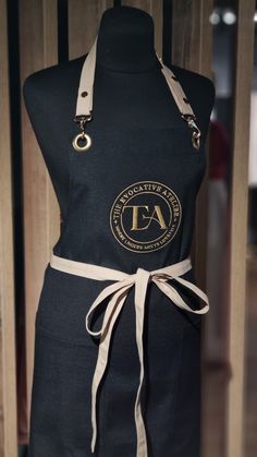 the apron is black and has a tan ribbon around it