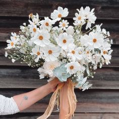 a person holding a bouquet of white flowers