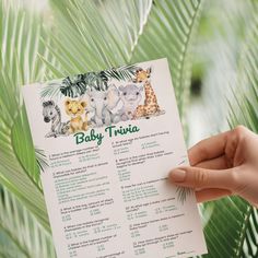 a person holding up a baby trivia in front of some palm leaves and trees