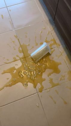 a roll of toilet paper sitting on top of a floor covered in spilled yellow liquid