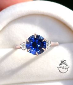 a close up of a ring with a blue stone in the middle and three diamonds around it