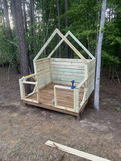 a small wooden structure in the middle of a forest