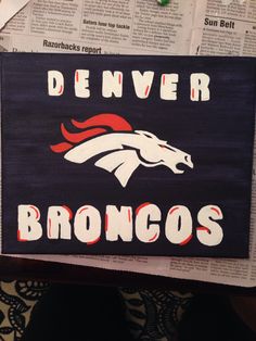 a denver football team sign is displayed on newspaper