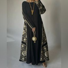 Black Double Sided Jalabiya With Light Gold Embroidery & Light Gold Piping. The Jalabiya Is A Double A-Cut Cut. Size Medium, 54” Black Kaftan With Dabka Work For Eid, Black Long Kaftan With Dabka Work, Black Dabka Work Kaftan For Eid, Eid Black Kaftan With Dabka Work, Evening Festive Abaya With Dabka Work, Traditional Black Maxi Dress For Festive Occasions, Long Sleeve Abaya With Dabka Work For Evening, Evening Abaya With Dabka Work And Long Sleeves, Black Embroidered Abaya For Wedding