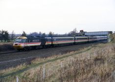 a train traveling down tracks next to tall grass