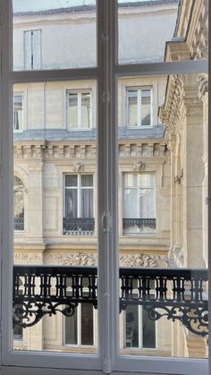 an open window with the view of a balcony and building in the backround