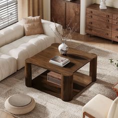 a living room with a white couch and wooden coffee table in front of a window