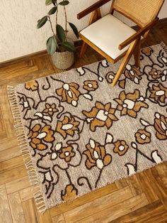 a brown and white rug sitting on top of a wooden floor next to a chair