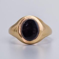 Solid 9K Gold Oval Onyx Ring This 9K gold ring showcases an oval black onyx as its centerpiece. The band features a smooth, rounded design that gently tapers from the central stone, providing a seamless flow and enhancing the prominence of the onyx. Hallmarked pre 1975 Vintage piece in good condition. Stone has slight movement in the setting but is secure. See images for more detail. Size - M Stone Dimensions - 7 mm x 9 mm Weight - 3.1g 9ct gold ✅ Domestic and international shipping options avai