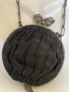 "Lovely Victorian Dainty silk purse with a delicate chain strap known as \"Opera Bags''. These small bags accompanied women on special outings. This bag has a decorative clasp and tassel. Inside are two compartments, one holding a small round mirror on a chain. Body of bag is 3.5\" across. Chain is 8\" long. Tassel is 3\" long. No holes or tears in exterior. Interior fabric is faded and a bit worn looking." Elegant Black Coin Purse For Evening, Elegant Black Evening Coin Purse, Elegant Compact Travel Bag, Elegant Black Pouch Coin Purse, Elegant Black Pouch-style Coin Purse, Elegant Clutch Coin Purse For Travel, Black Victorian Style Bags For Formal Occasions, Black Victorian Style Formal Bag, Black Evening Coin Purse With Removable Pouch