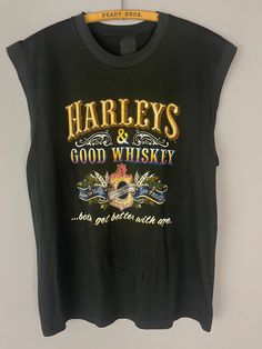 "Vintage Harley Davidson motorcycle tank top/T-shirt, Harley's and Whiskey rare graphic New York, muscle tee, soft worn in 80s biker shirt TAG SIZE: n/a MATERIAL: n/a MEASUREMENTS LAYING FLAT in INCHES: SHOULDER TO SHOULDER: 18 1/2\" ARMPIT TO ARMPIT: 20 1/2\" LENGTH TO WAISTLINE: 25\" # 402 ALL T-SHIRTS IN MY SHOP ARE TRUE GENUINE VINTAGE, NOT REPRINTS! I AM HAPPY TO COMBINE SHIPPING ON MULTIPLE ITEMS, IF YOU HAVE ANY QUESTIONS OR REQUESTS PLEASE FEEL FREE TO REACH OUT AND I WILL ACCOMMODATE YO Fitted Sleeveless Grunge T-shirt, Vintage Sleeveless T-shirt With Graphic Print, Vintage Tank T-shirt For Summer, Tank T-shirt With Letter Print For Streetwear, Fitted Cotton Muscle Tee With Graphic Print, Fitted Sleeveless Graphic Print T-shirt, Vintage Print Band Merch Crew Neck Top, Vintage Cotton Muscle Tee For Summer, Grunge Crew Neck Tank Top With Letter Print