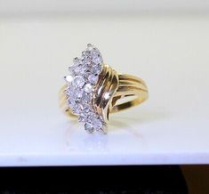 a yellow gold ring with three diamonds on it's sides, sitting on a white surface