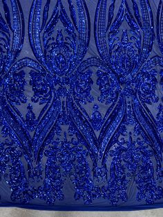 blue sequins embellished mesh fabric on a piece of cloth with an intricate design