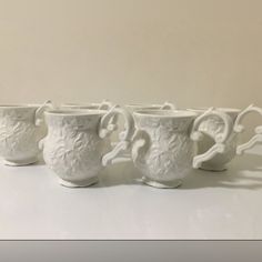 four white coffee mugs sitting next to each other