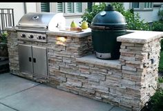 an outdoor bbq with grill, sink and potted plants on the outside wall