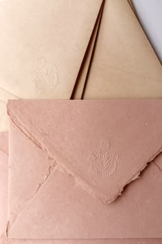 three envelopes sitting on top of each other, one with a waxed stamp