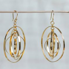 Concentric rings spin freely within each other in these great earrings from Carlos and Cynthia Rendon in Mexico. The dangle earrings are crafted from gleaming 24k gold plated zinc. Modern Cadmium-free Drop Earrings, Modern Gold Hoop Linear Earrings, Gold Hypoallergenic Linear Earrings For Anniversary, Gold Round Chandelier Earrings For Anniversary, Gold Plated Round Chandelier Earrings, Gold Round Linear Earrings, Cadmium-free Yellow Gold Dangle Earrings, Gold Nickel-free Round Linear Earrings, Nickel-free Gold Linear Earrings