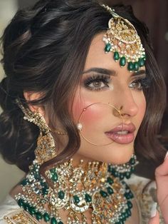 a woman in a bridal outfit with jewelry on her head