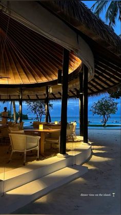 an outdoor dining area on the beach at night