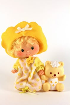 a small doll with a teddy bear on a white background